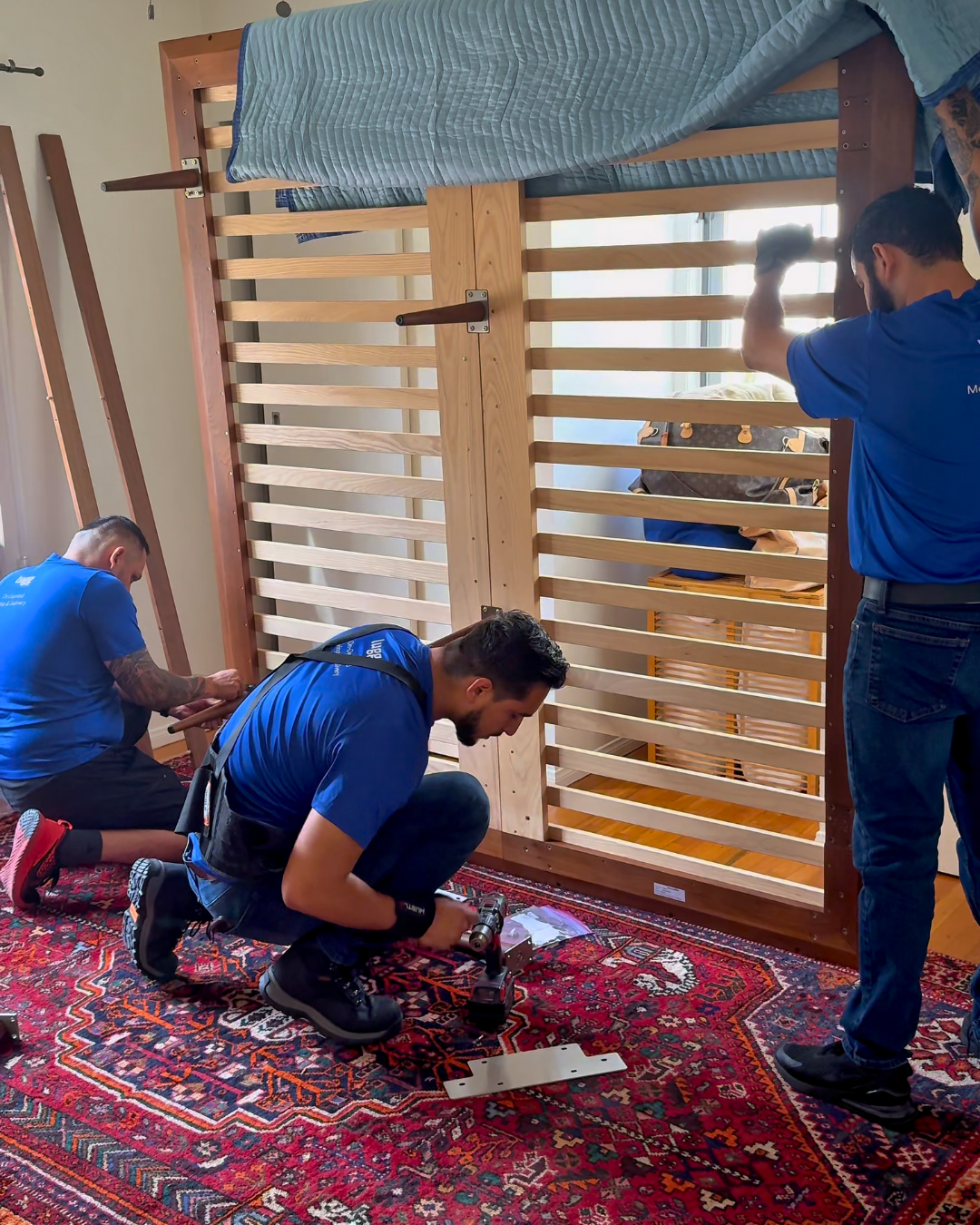 Lugg movers assemble a bed frame inside a new home, helping customers finish their move and get settled quickly.
