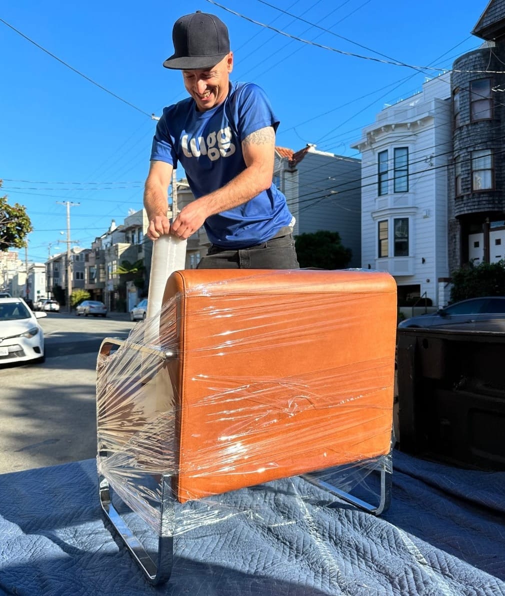 Lugg mover carefully securing furniture with straps for safe transport on a San Francisco street