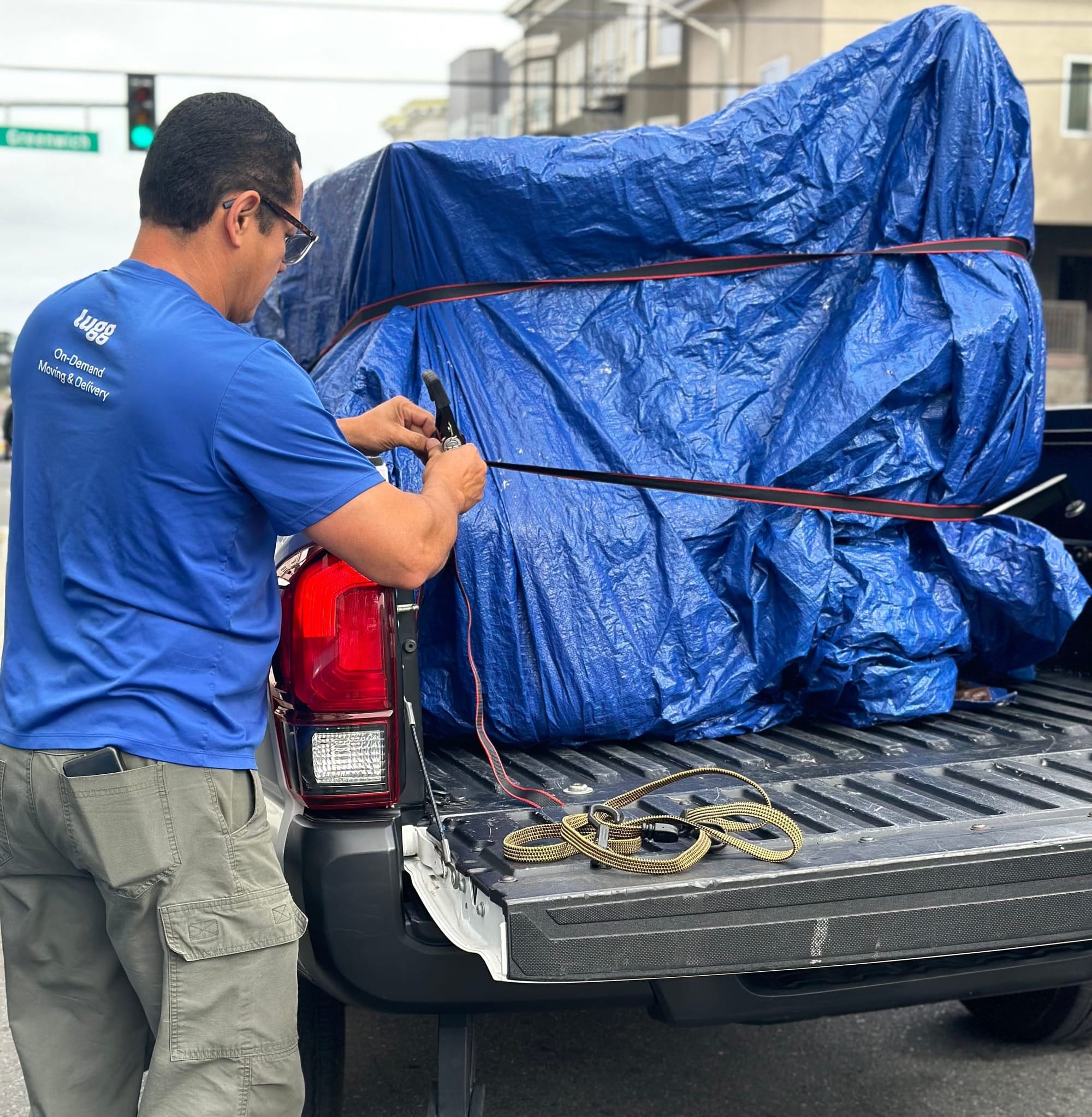 Lugg mover securing furniture with tie-down straps on a pickup truck bed