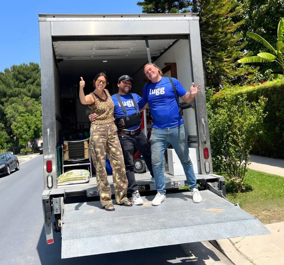 Happy customer giving a thumbs up with two Lugg movers on a box truck ramp after a local move