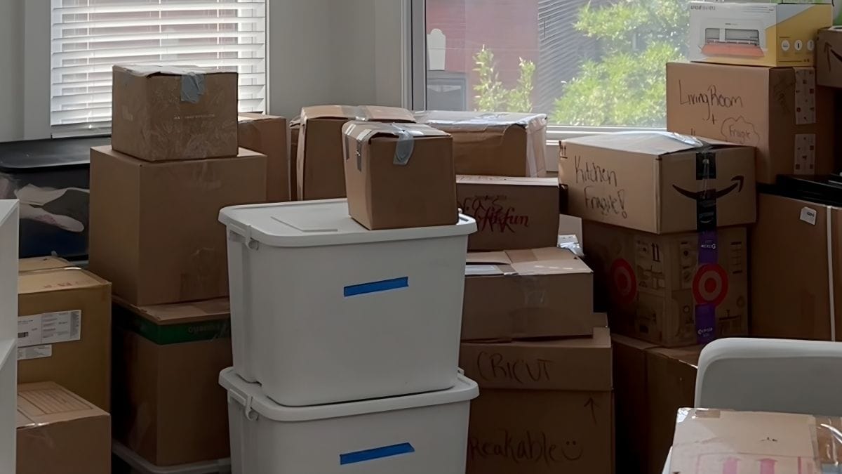 A dorm room packed with labeled cardboard boxes, plastic bins, and bags ready for move-out day