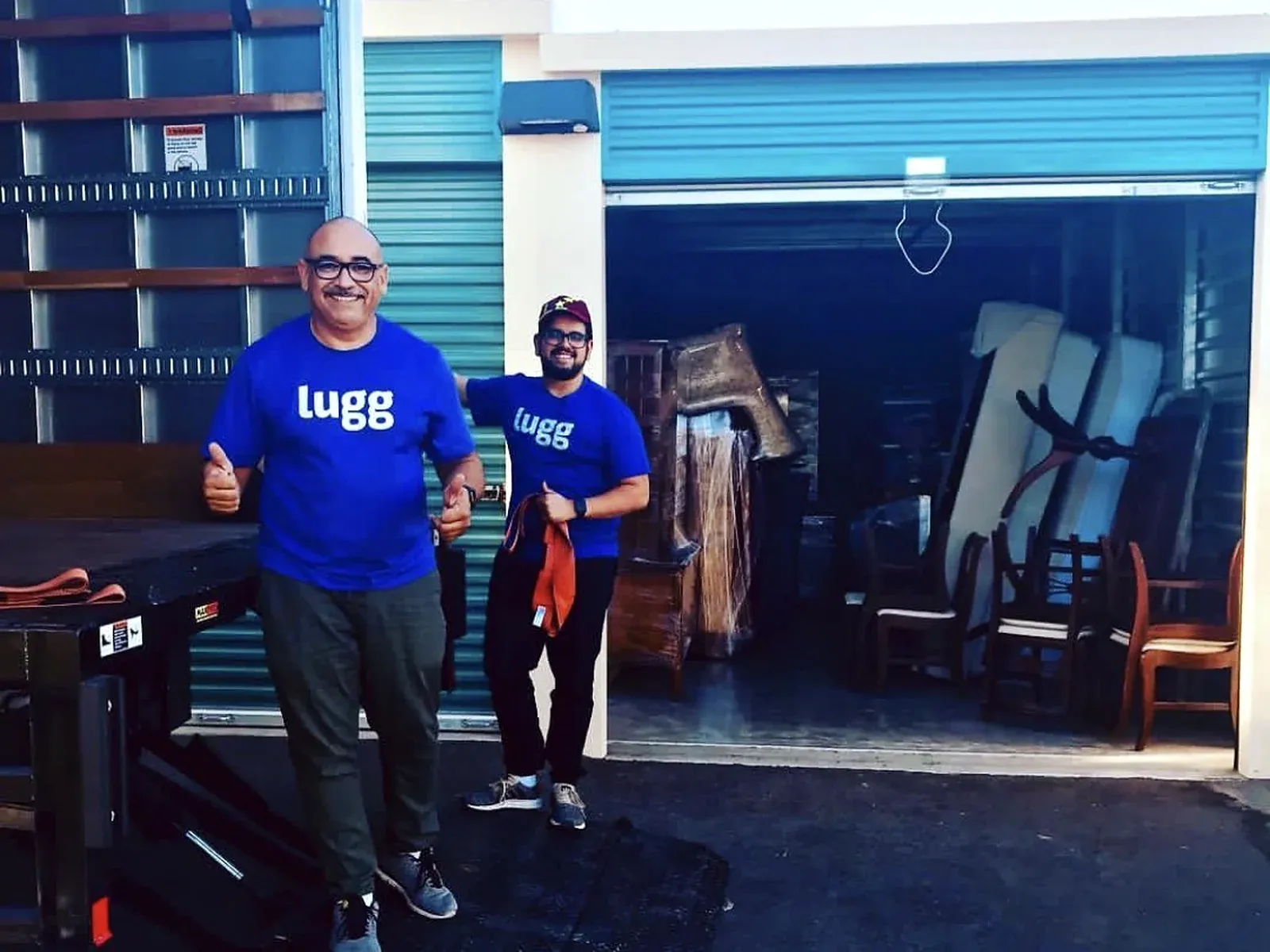 Edgar and another Lugg mover standing outside a storage unit filled with furniture.