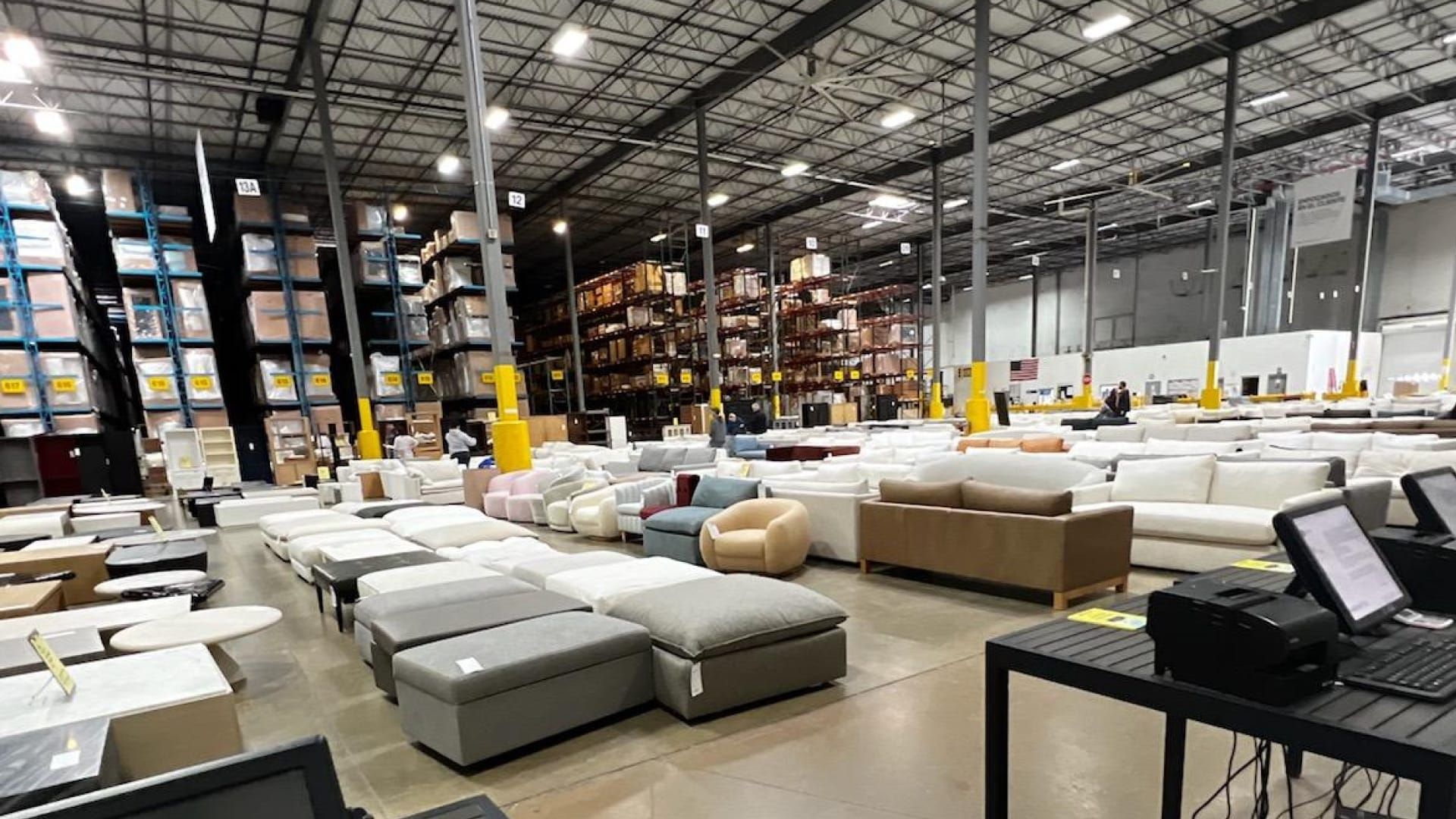 Warehouse-style discount furniture outlet filled with sofas, sectionals, and ottomans at clearance prices