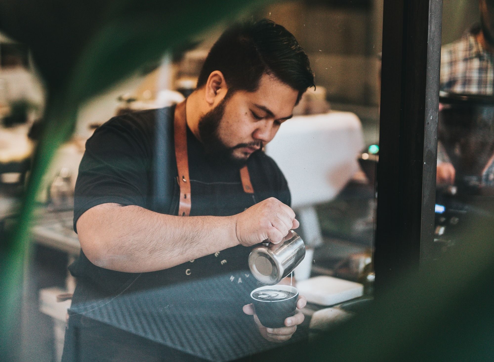 man pouring coffee in cup