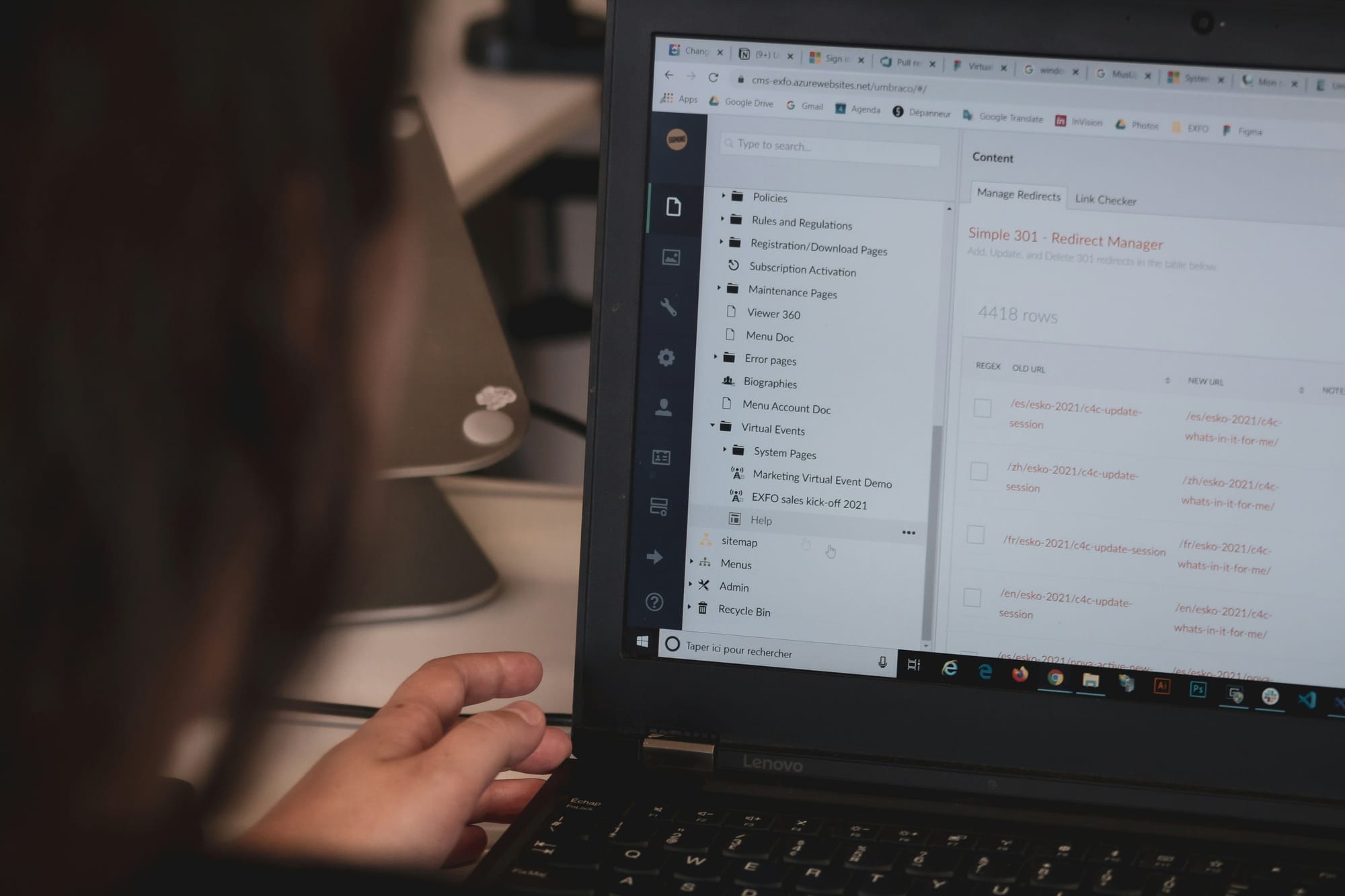 Someone working in a traditional content management system (CMS) on a Lenovo laptop.