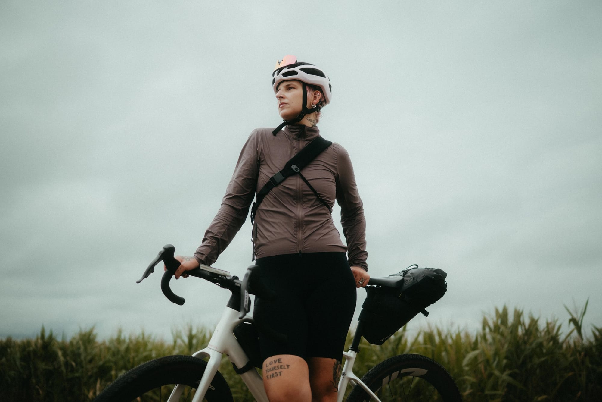 Jana standing with her bicycle beside the cornfield