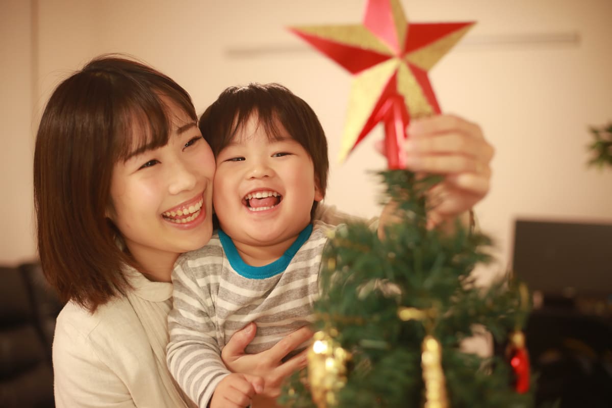 クリスマスツリーを飾る親子