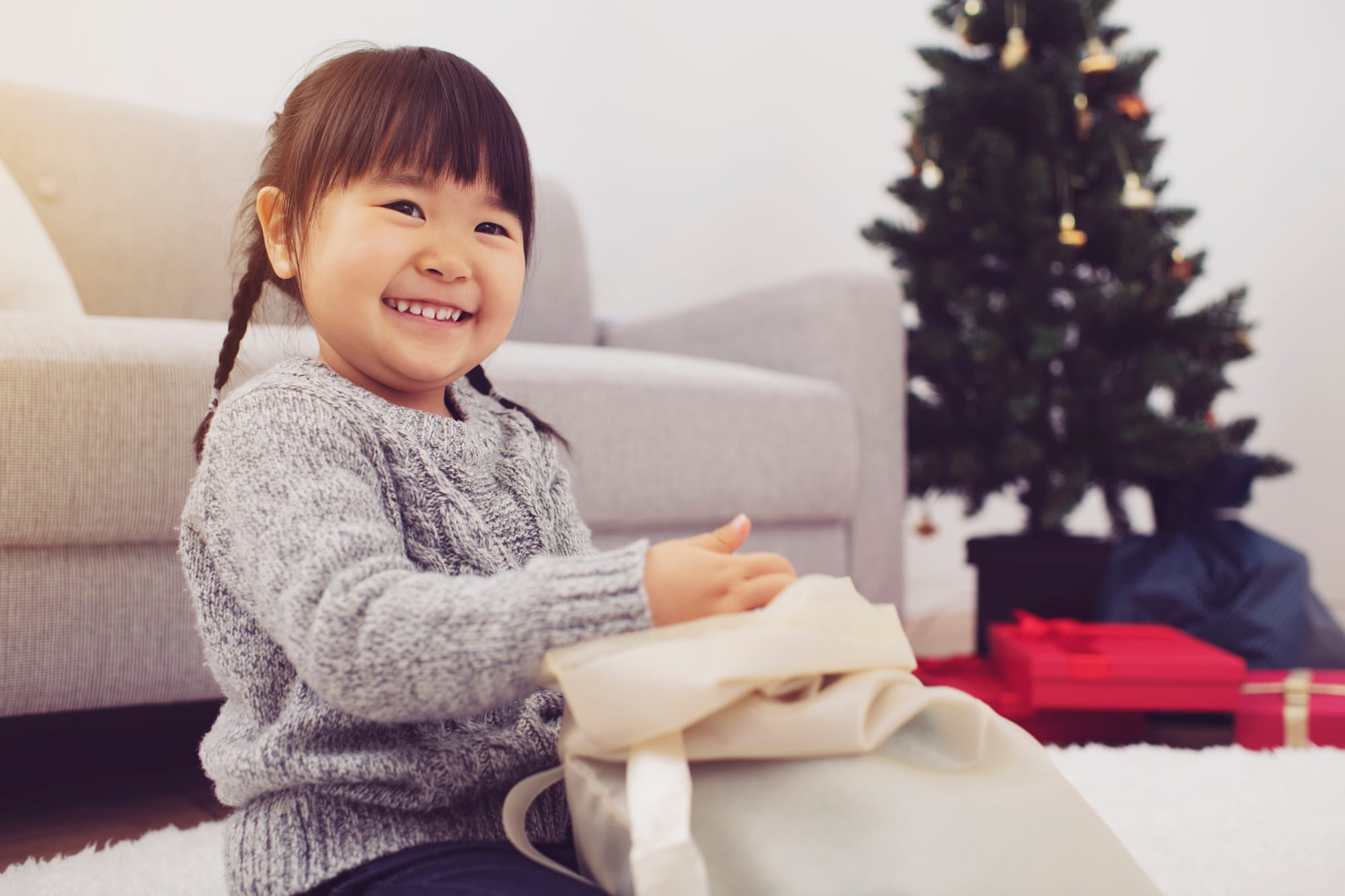クリスマスプレゼントを開ける子供の笑顔