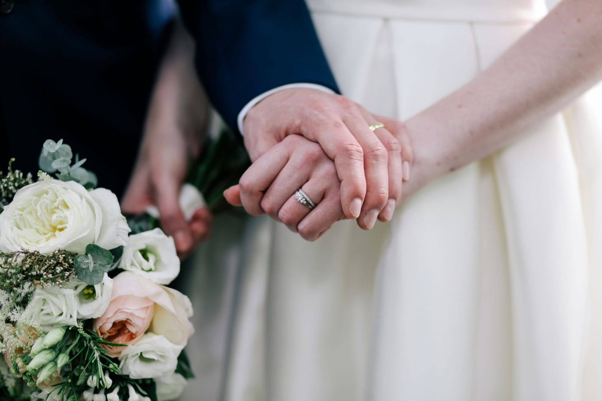 結婚式で手を重ねる新郎新婦