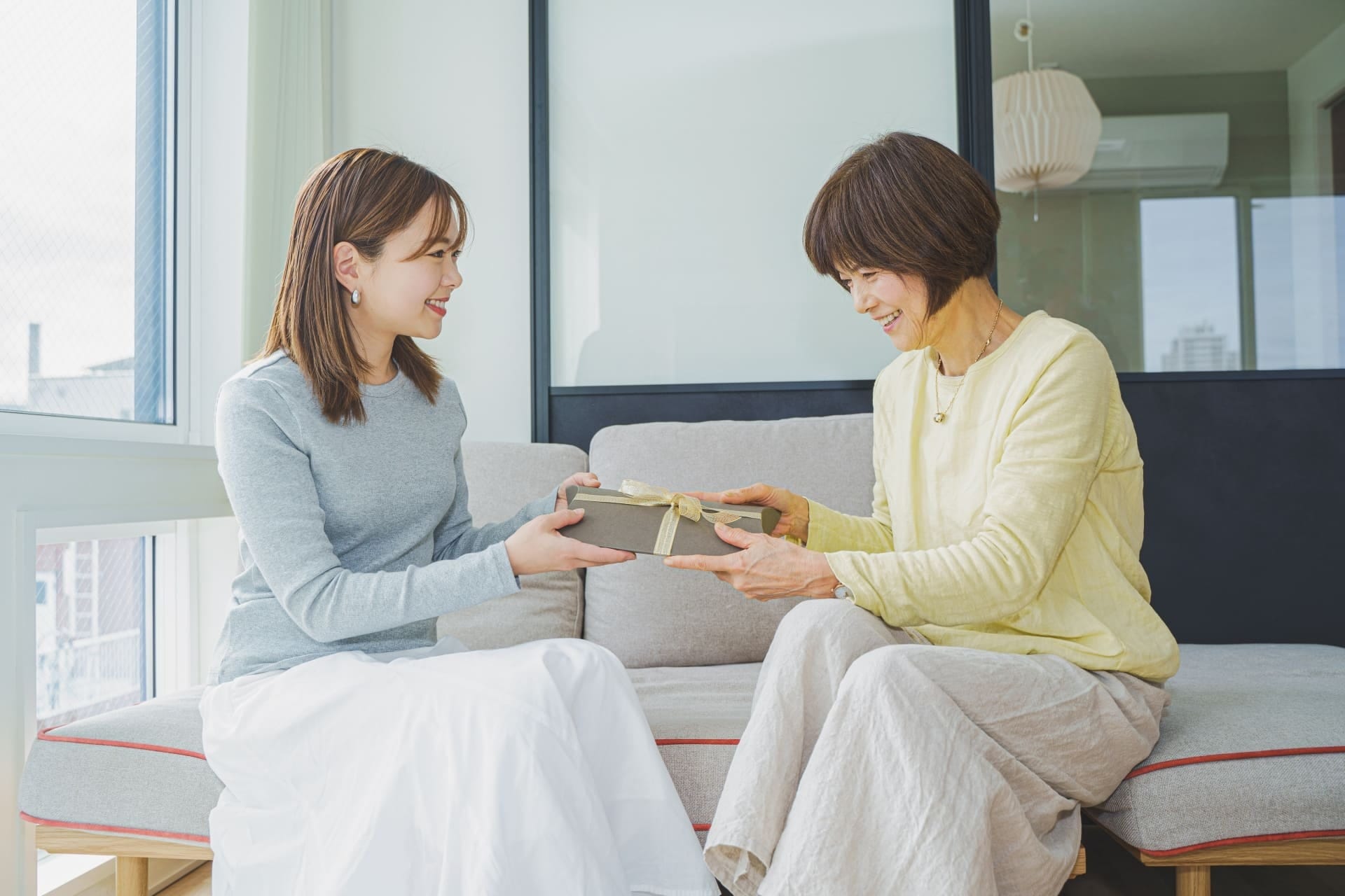 笑顔でお返しのプレゼントを渡す女性