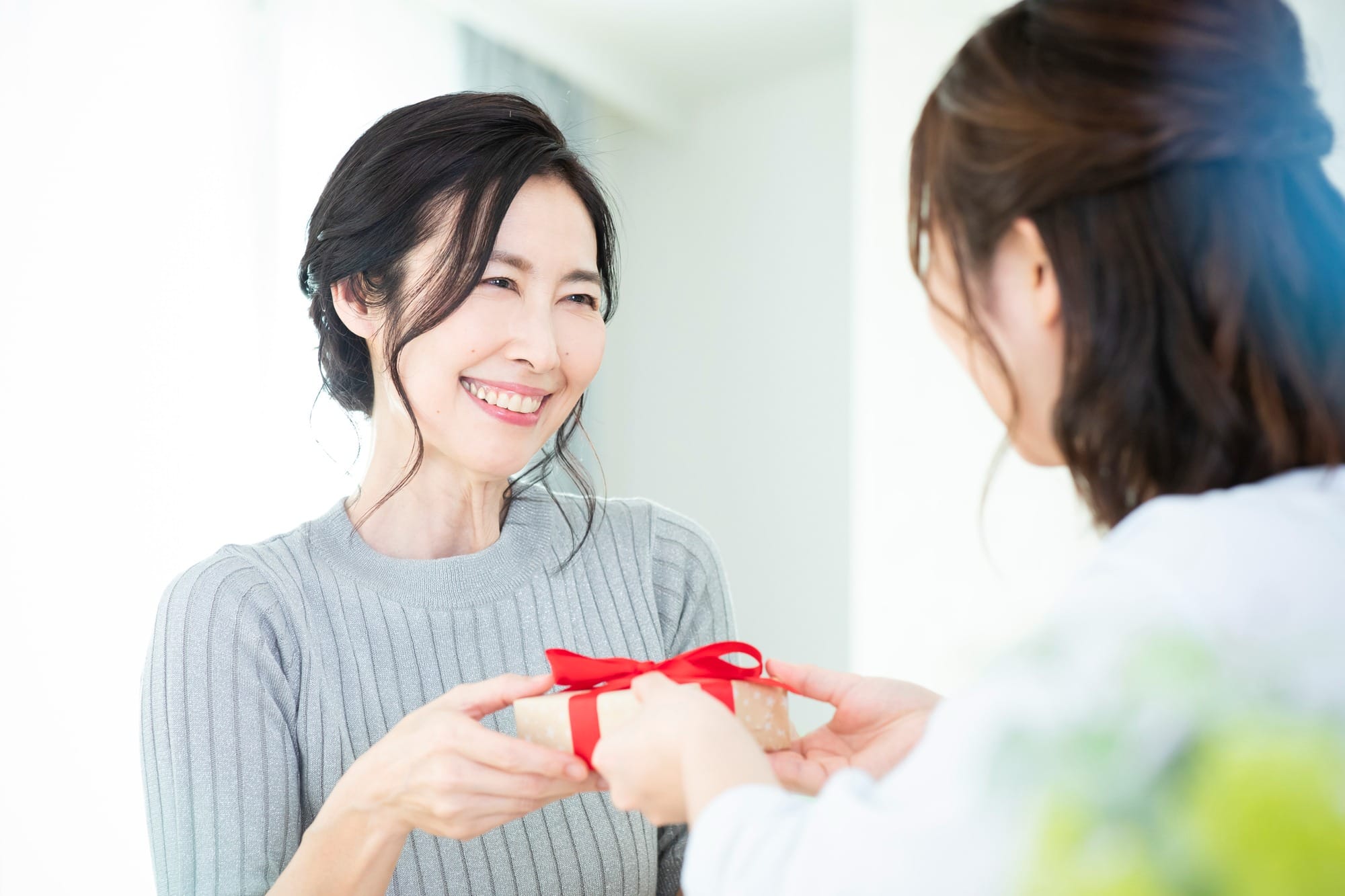 贈り物を手渡す女性と受け取る女性