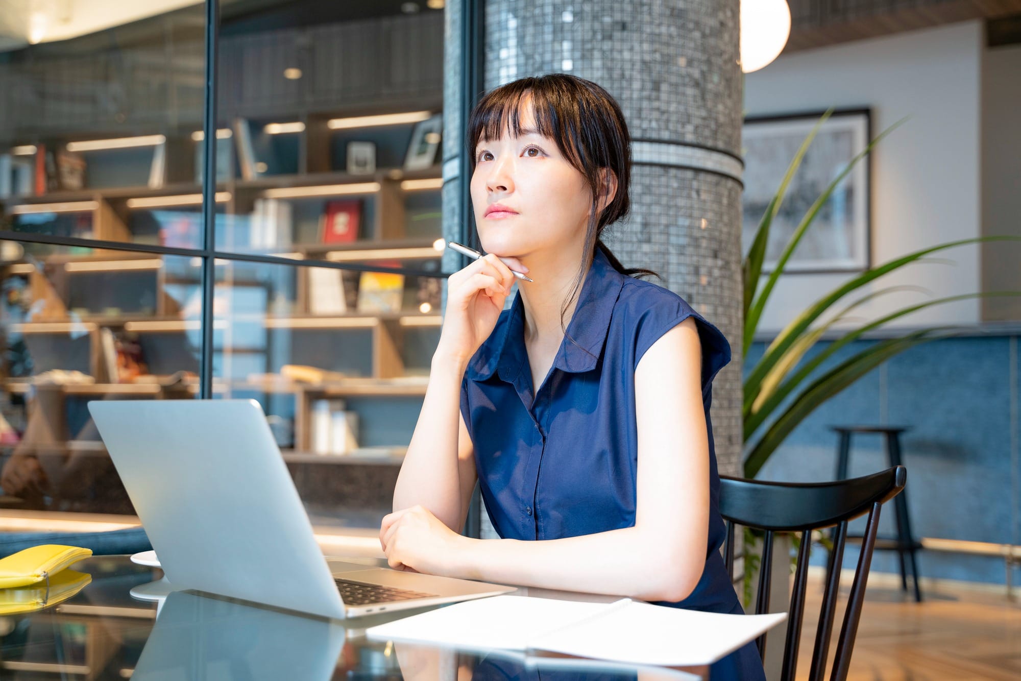 メモを取りながら考えている女性