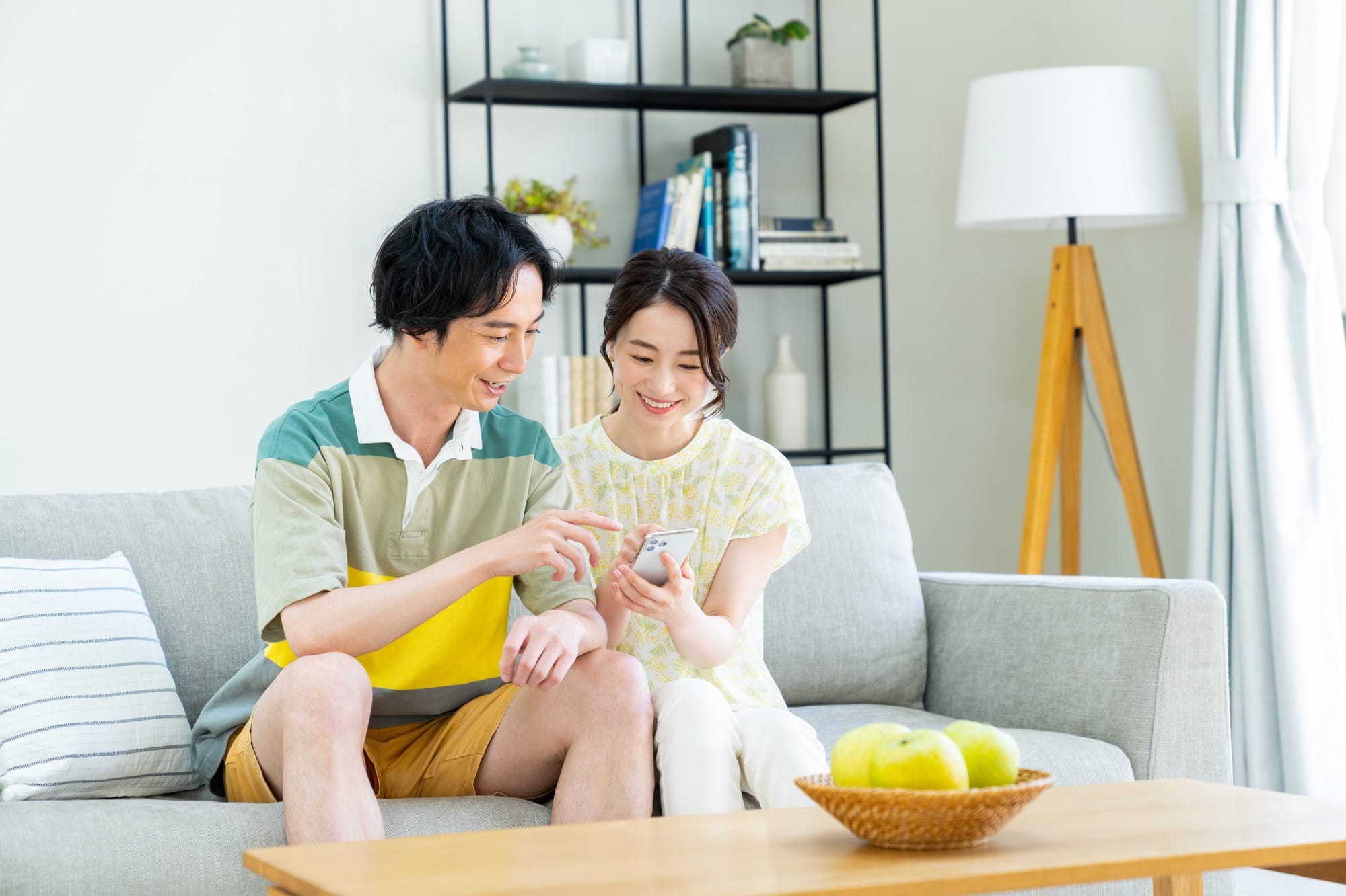 スマートフォンを見ながら体験を選んでいる夫婦