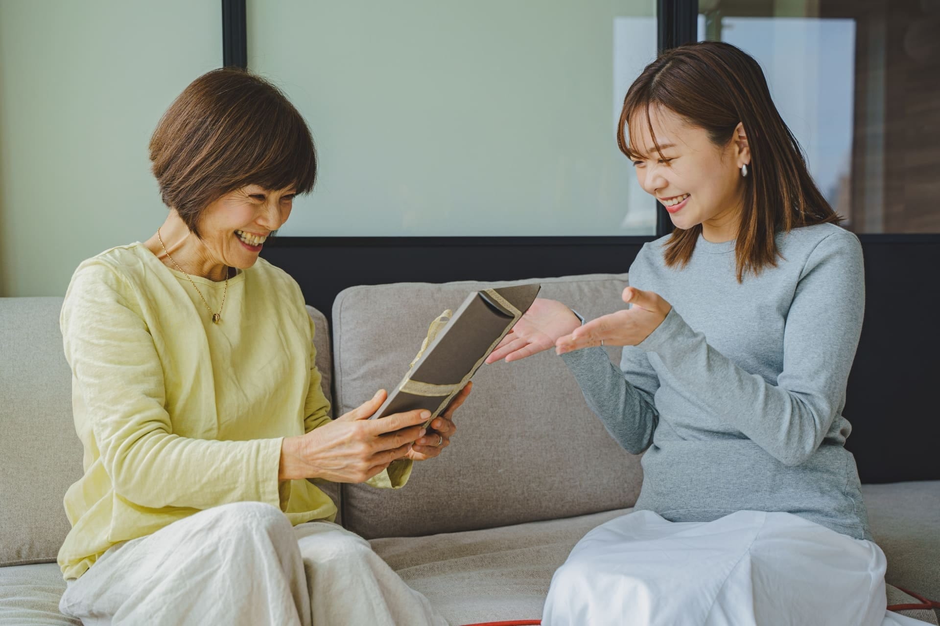 誕生日プレゼントを受け取って喜ぶ母親
