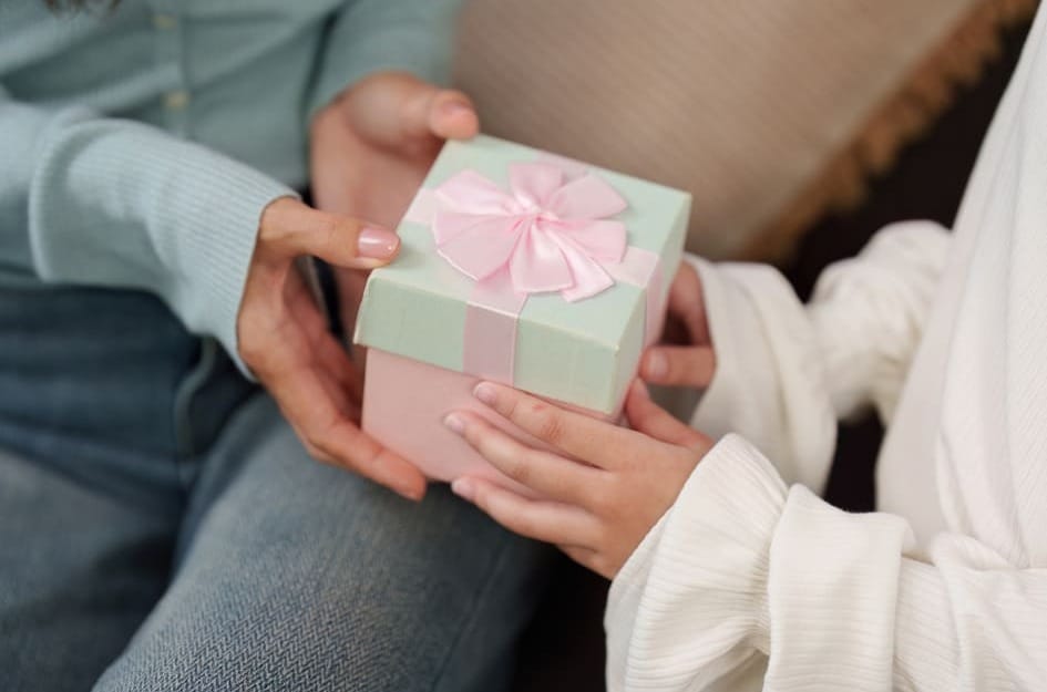 子どもから40代の母親に誕生日プレゼントを渡す様子