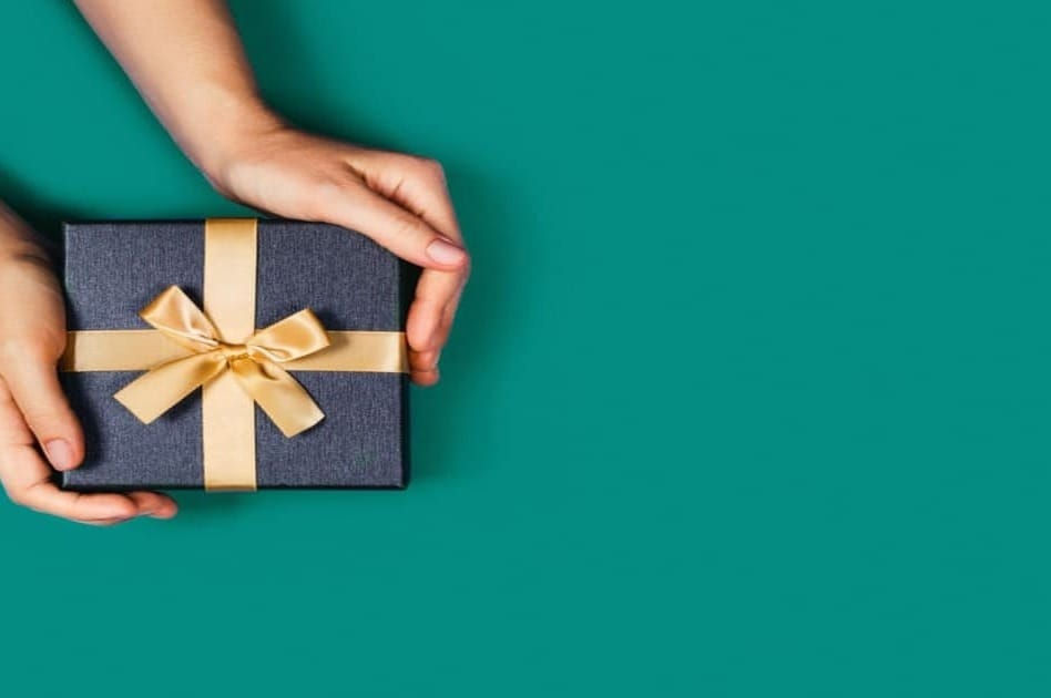 60代の父親への誕生日プレゼントを持つ人の手元