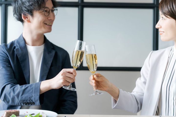 クリスマスディナーでシャンパンで乾杯するカップル