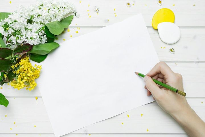 白い紙に結婚祝いメッセージを書く手元