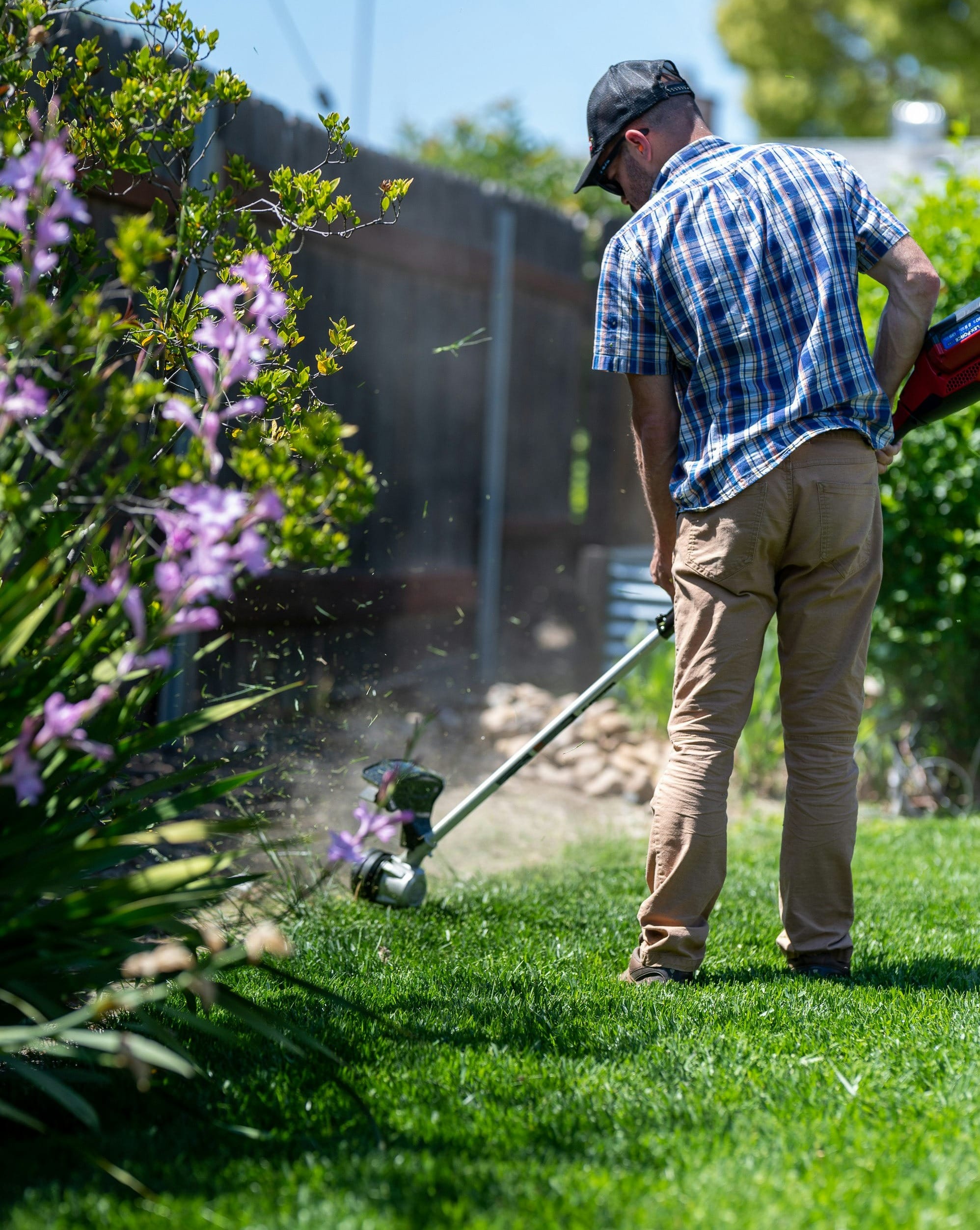 a man using a lawn mower to cut grass