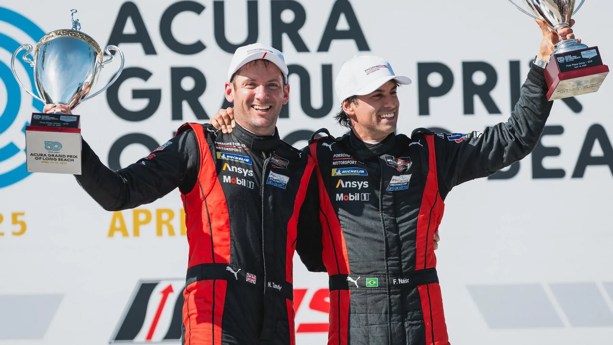 Nick Tandy and Felipe Nasr holding their trophies and celebrating after winning the race at Long Beach..