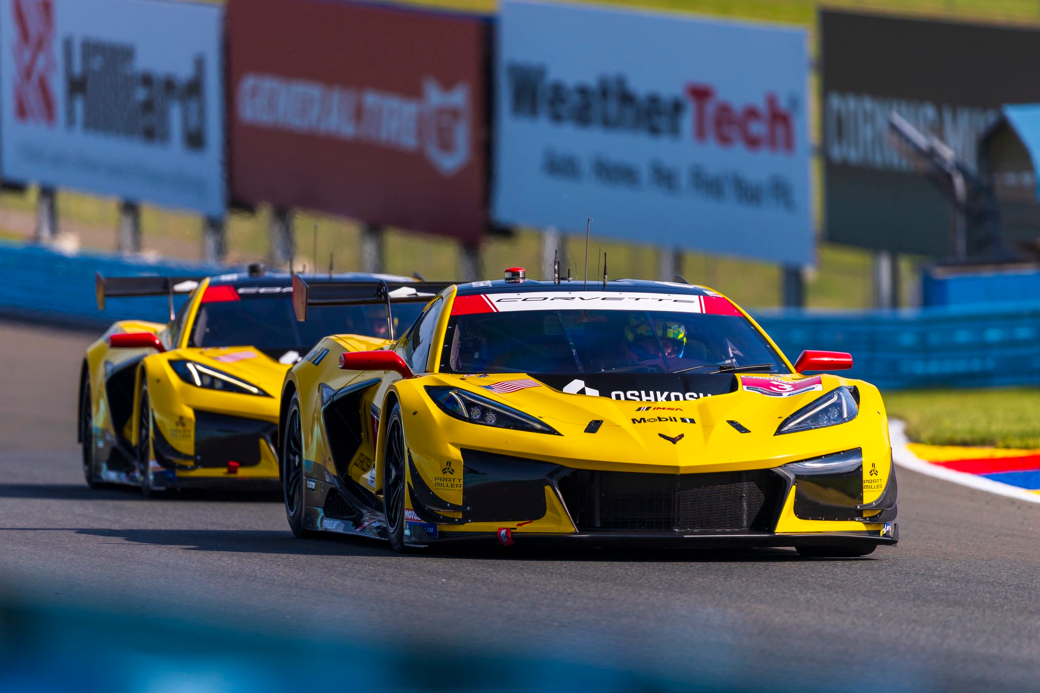 The two yellow Corvette Racing Z06 GT3.R cars at Watkins Glen in bright sunshine, 2025