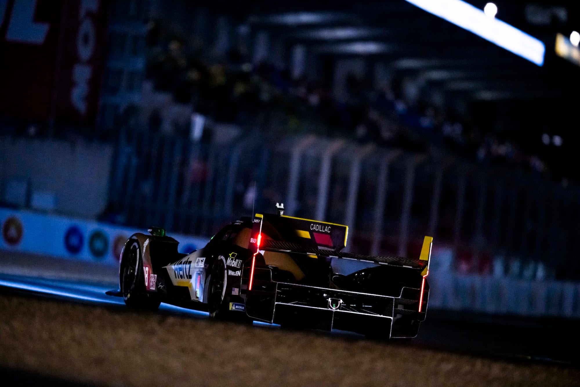 A Cadillac V-Series.R during the night at Le Mans 2026, taken from the rear as the car drives away