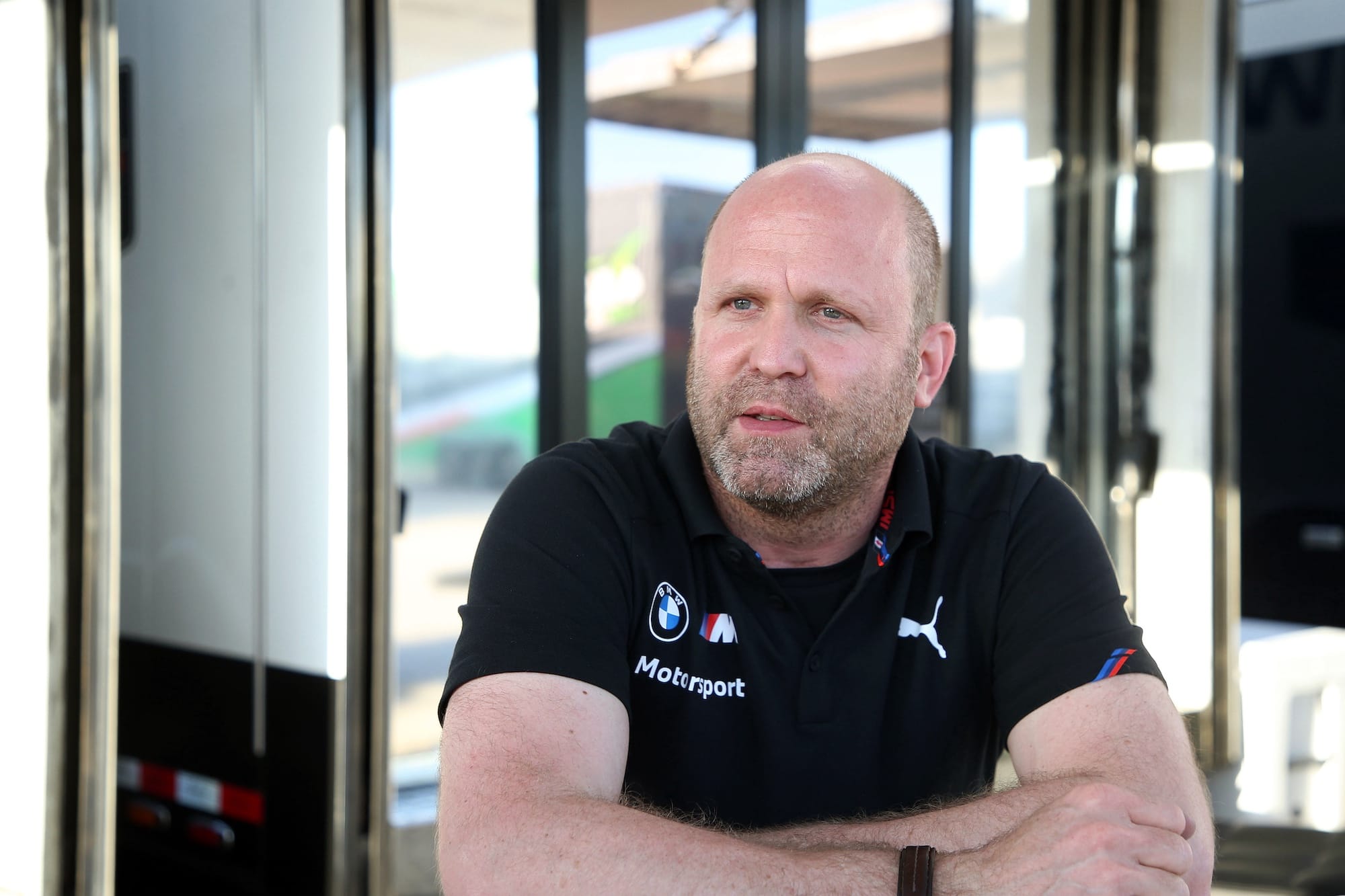 BMW's Andreas Roos with his arms crossed in a hospitality area, in a BMW shirt
