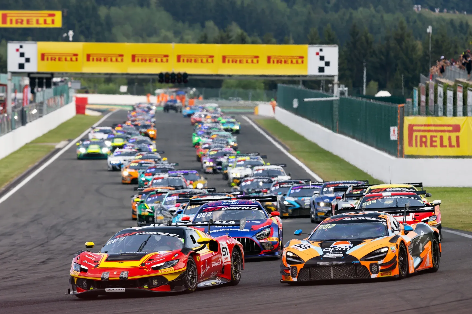 Cars at the start of the 2026 Spa 24 Hours, with the leaders turning into La Source hairpin as the rest of the field snakes its way down the main straight