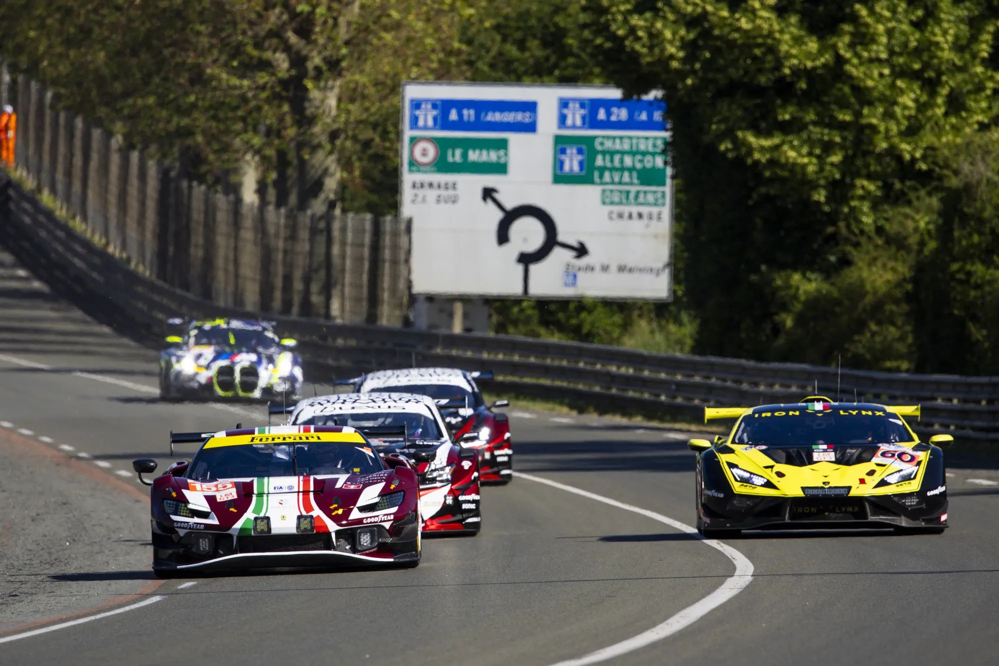 A Ferrari, Lamborghini, BMW, and Porsche GT3 cars on the Mulsanne Straight at Le Mans. Image: Julien Delfosse / DPPI