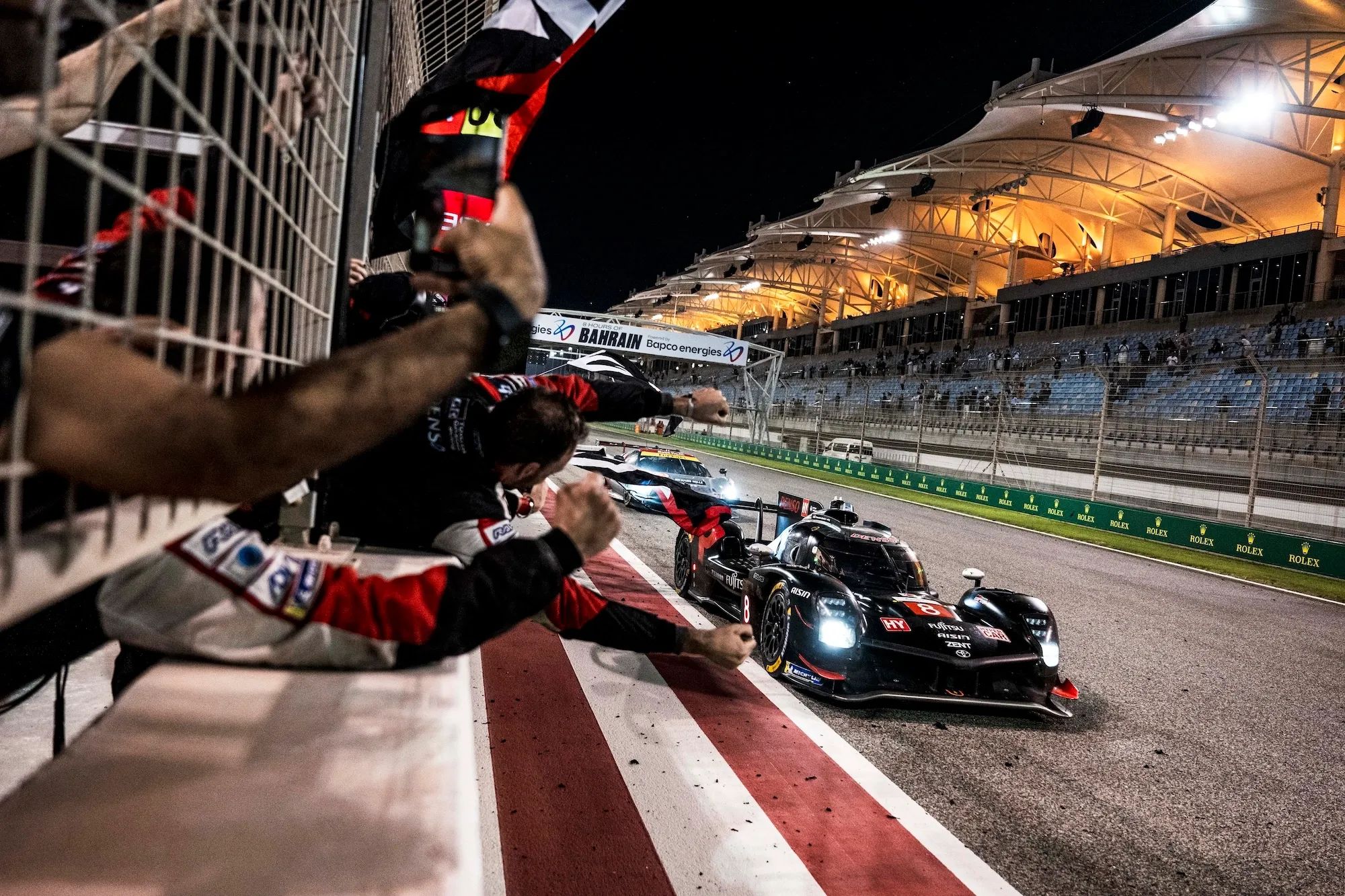 Mechanics cheering on the pitwall as the #8 Toyota crosses the line to win. Image: Charly Lopez / DPPI