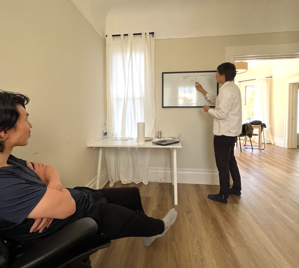 Charlie, sitting and Yitong at the whiteboard mapping out a protocol in April of 2023
