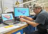 A machinist checks output of a milling machine.