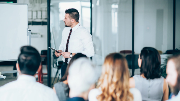 Automotive training consultant leading a professional development session to help dealership employees improve their skills, processes, and overall performance.