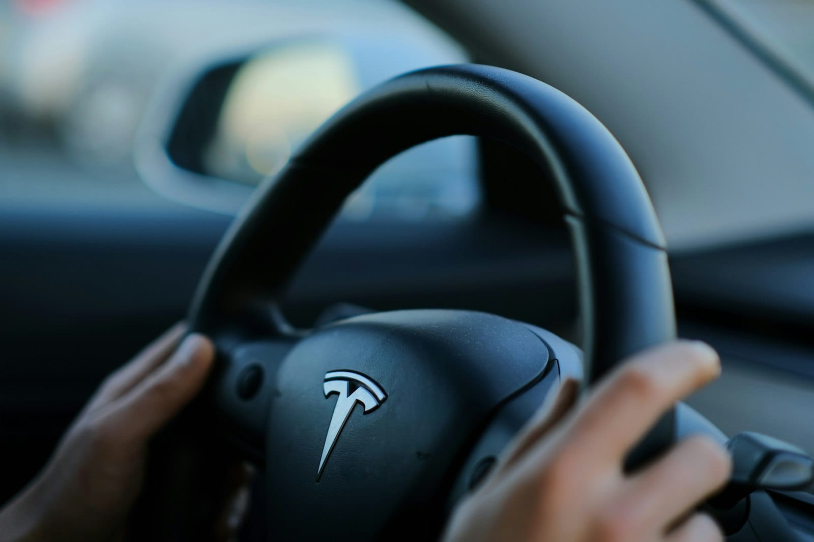 A person holding a steering wheel while driving a car