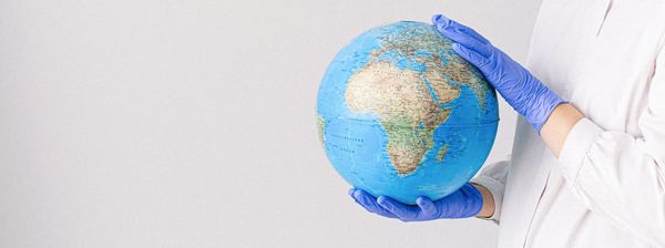 Hands with gloves holding a globe