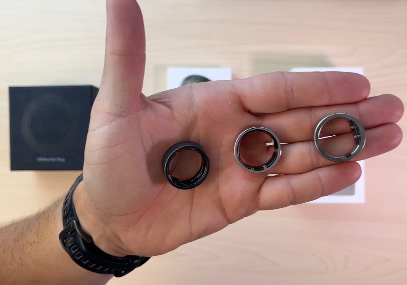 Ultrahuman R1, Air and Ring PRO held in a hand for size comparison