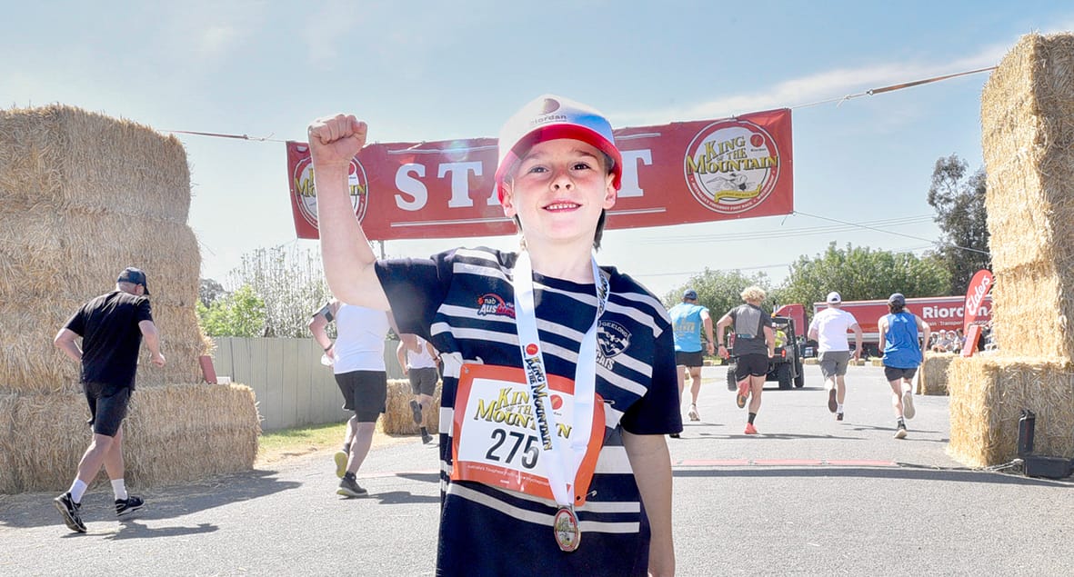 A possible “Mountain Man” of the future, seven-year-old Max Coatsworth celebrated his participation in the Boys Dash as runners take off for the next climb to the top in last Saturday’s Riordan’s Wycheproof “King of the Mountain”. ­(Photo by Jenny Pollard.)