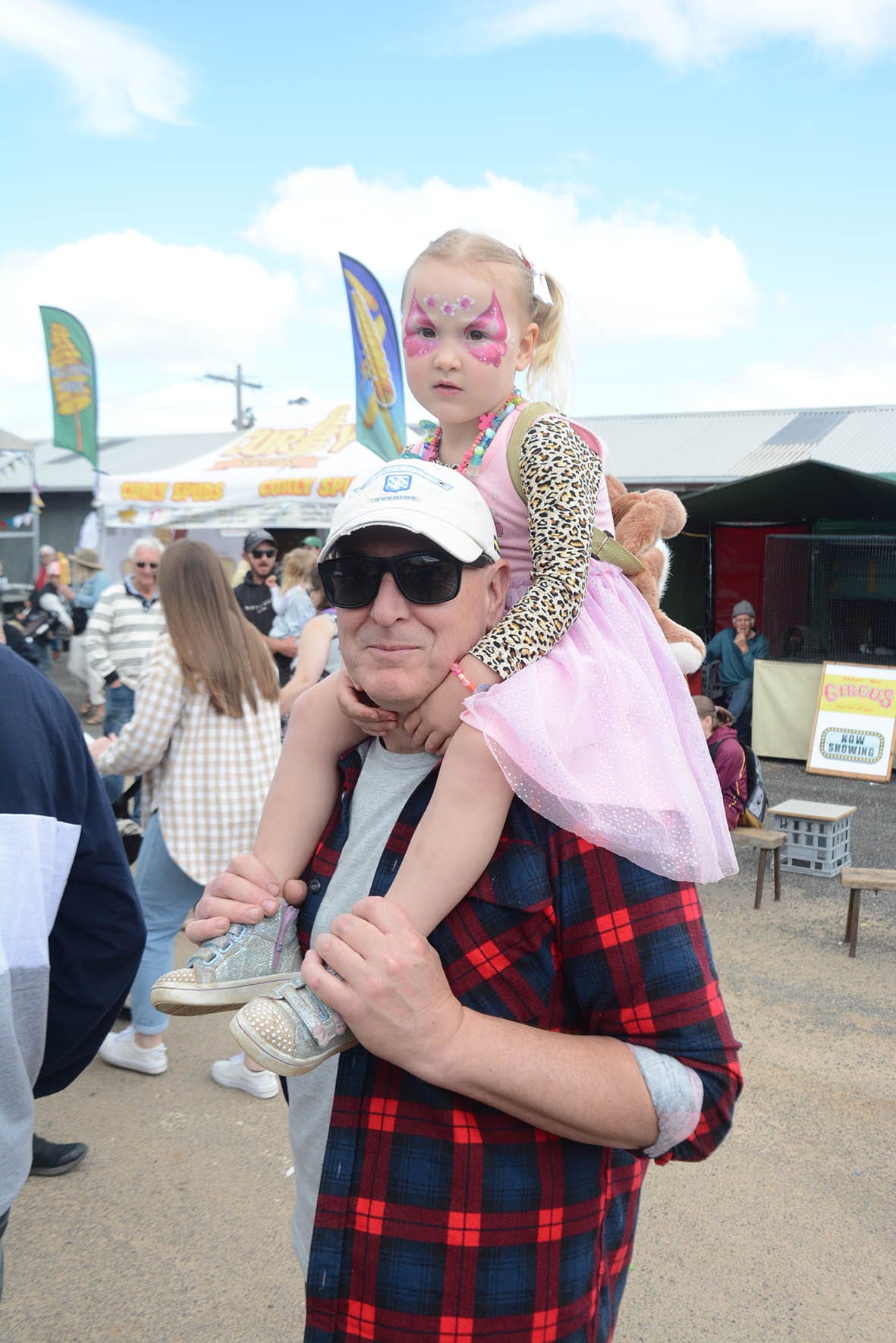 Three-year-old Valentina Harris takes a ride on the shoulders of her Day, Nathan, so that she can get a bird’s eye view of the Donald Show activities.
