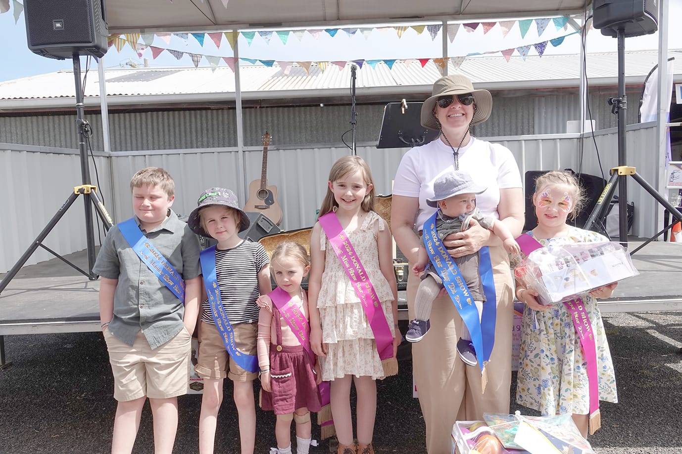 Show Stars left to right: Jaxon Krause (Master 8-12), Edison Francis (Master 4-7 years), Lorelei Francis (Tiny Tot Miss 0-3 years), Marlie Adams (Miss 4-7 years), William Schintler (Tiny Tot Mister 0-3 years) (held by Mum), Sophie Duynhoven (Miss 8-12 years). –Photo Jodie Drake.