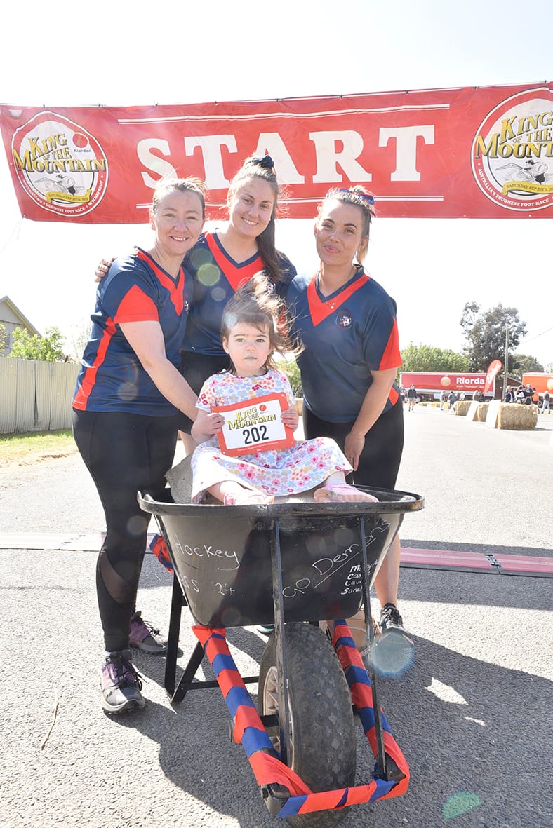 Members of the premiership-winning Wycheproof hockey team, left to right, Laura Harrison, Mary-Anne Pollard and Cassie Pardella, share a moment with two-year- old Ruby before setting off in the Women’s Wheelbarrow race. Fellow team member, Sarah Botheras was already in place for the relay event. ­(Photo by Jenny Pollard.)