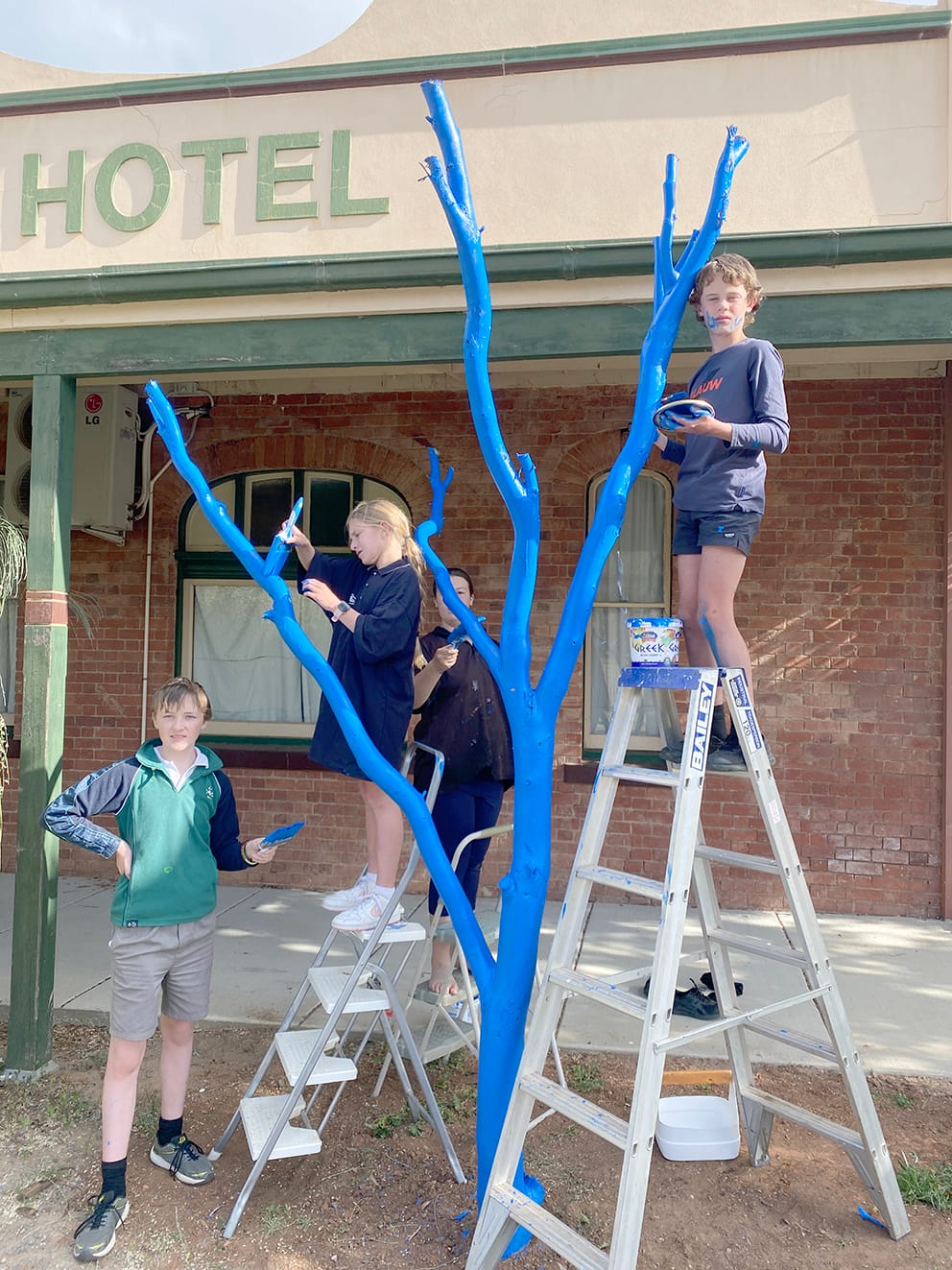 Blue Tree project: Members of the Birchip Art Club, Michael Darby, Ivy Bourke, Steph Trickey and Archie Tyler paint Birchip’s Blue Tree.