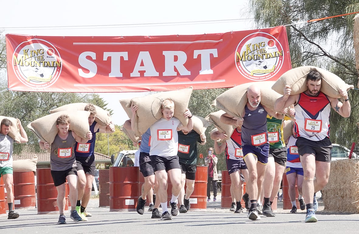 The beginning of the gruelling King of the Mountain race, with men carrying a whopping 60kg bag of the Mallee’s finest wheat to the top of Mt. Wycheproof. (Photo bt Jodie Drake).