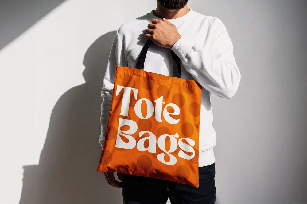Hand Held Tote Bag Mockup with Sunlight on White Wall