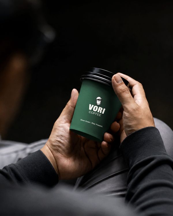 Hand Holding Paper Coffee Cup Mockup in Dark Lifestyle Environment