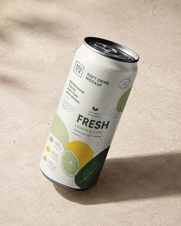 Aluminum drink can mockup with fresh lemon and lime beverage branding in a natural outdoor setting.