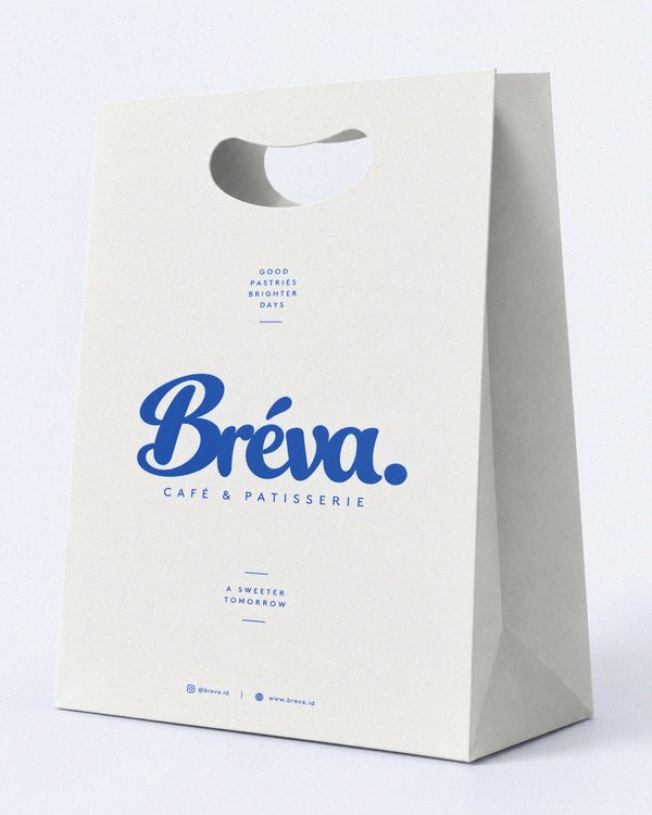 Bakery paper bag mockup featuring a clean white shopping bag with bold blue Bréva branding, a die-cut handle, and a minimalist studio presentation.