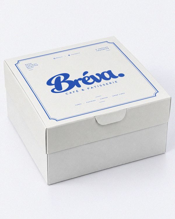 Cake pastry box mockup featuring a premium white cardboard box with elegant blue typography and a decorative border, presented on a clean studio background.