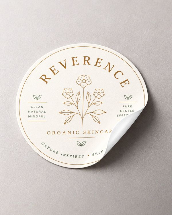 Cosmetic round sticker mockup featuring an ivory circular label, botanical illustrations, and elegant gold and green details on a textured neutral background.