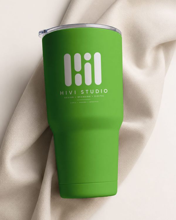 Green tumbler cup mockup displayed against soft fabric with natural lighting.