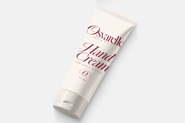 Ivory hand cream tube mockup with burgundy skincare branding on a light gray background.
